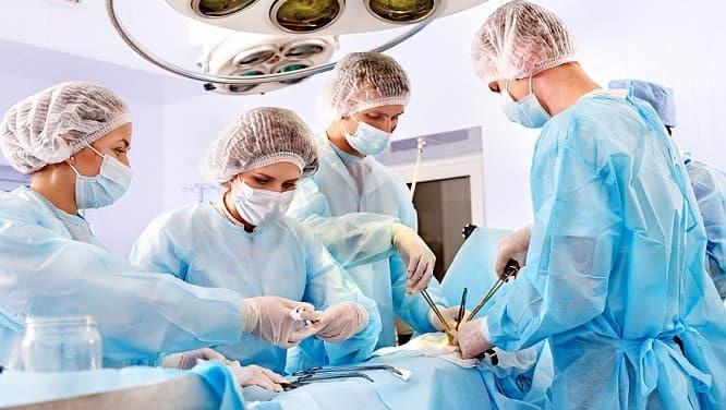 Médicos fazendo cirurgia e antibioticoprofilaxia