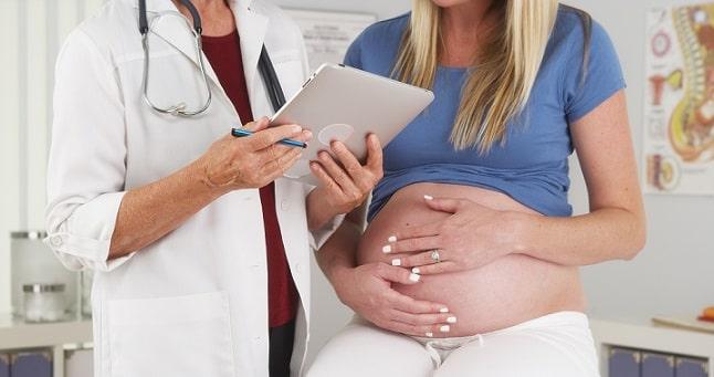 médica avaliando mulher grávida com apendicite, que é comum em gestantes
