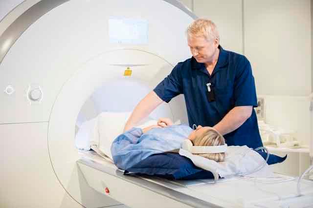 radiologista preparando paciente para tomografia