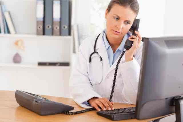 médica no telefone em seu consultório
