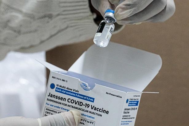 mão de técnico segurando dose de vacina da janssen